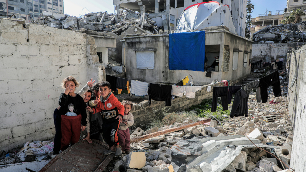 https://unsplash.com/photos/a-group-of-people-standing-next-to-a-pile-of-rubble-703Sobdug5o