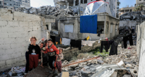 https://unsplash.com/photos/a-group-of-people-standing-next-to-a-pile-of-rubble-703Sobdug5o